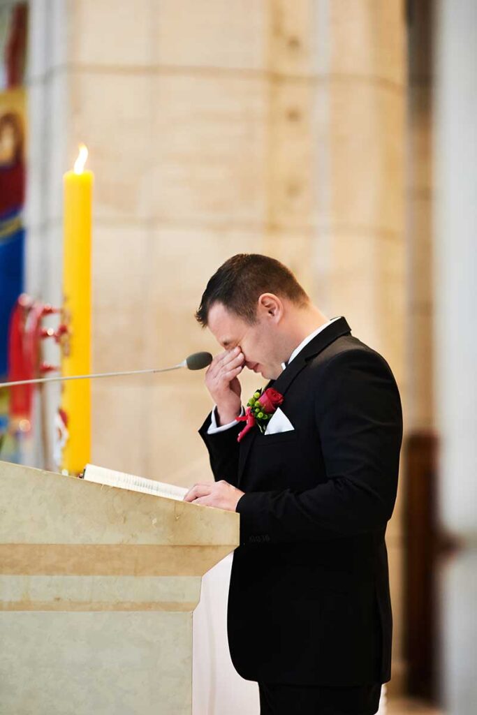 Reportaż ślubny 90 wzruszony pan młody czyta pismo święte