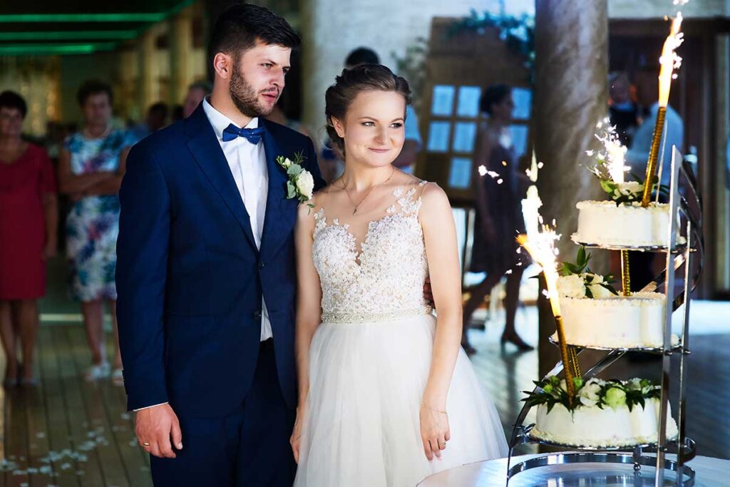 Reportaż ślubny 123 para młoda w trakcie krojenia torta weselnego